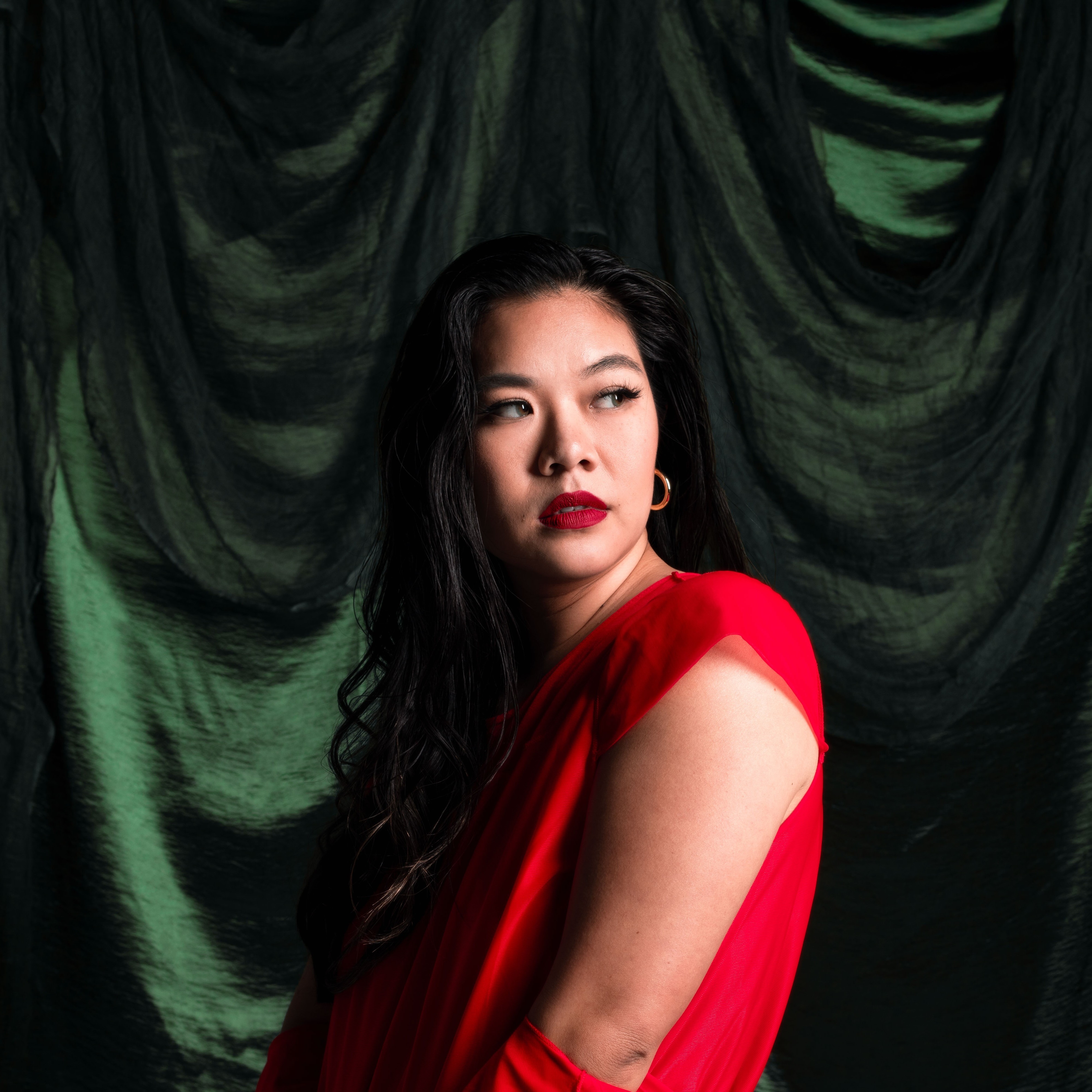 Stylized blue duotone portrait of a person facing the camera with arms crossed